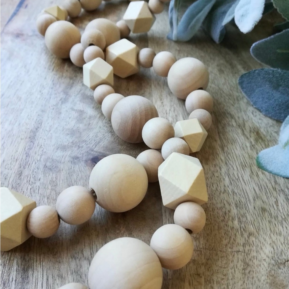 Decorative wooden beads with round and hexagon shapes. Tassels on the ends.